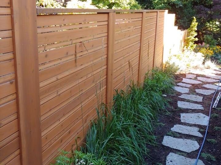 Custom cedar privacy fence with horizontal slats along a stone-paver garden path in the Fraser Valley