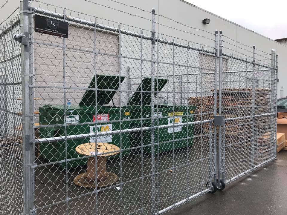 Commercial galvanized chain-link compound with barbed wire topping and cantilever sliding gate securing a strata waste and compactor area in Abbotsford, BC.