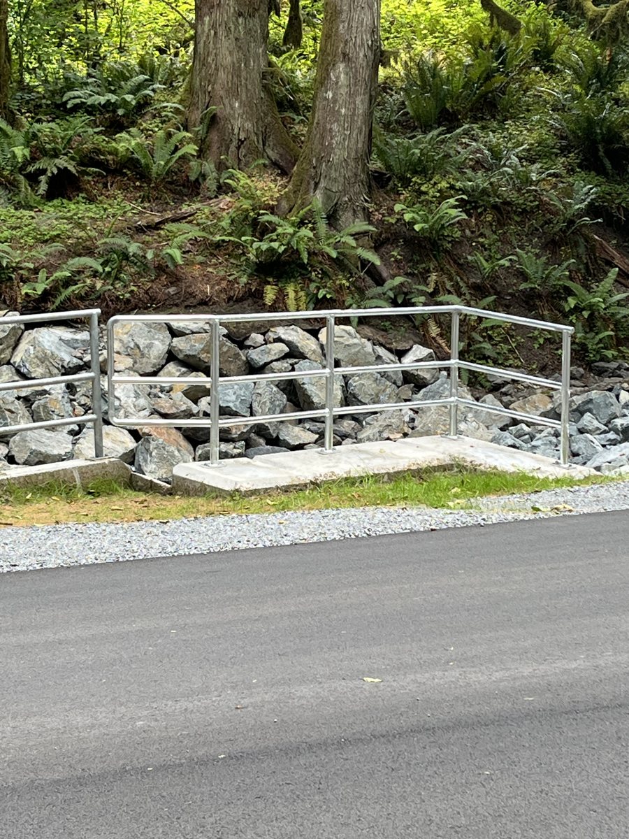 Galvanized handrail beside a rock retaining wall — photograph supplied by LS Fencing & Metal Work
